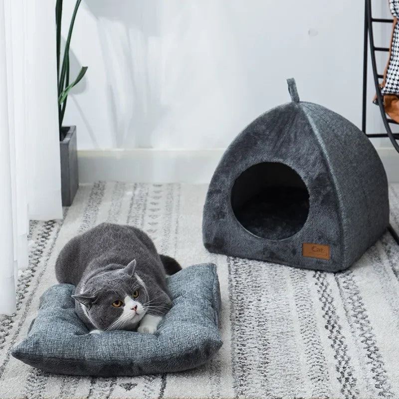 Two triangle cat nests on rug with gray cat resting beside cozy home decor