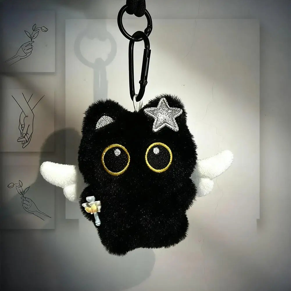 Black plush cat keychain with wings on dark background
