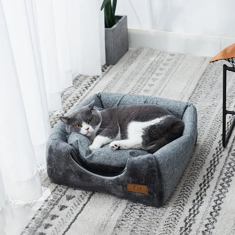 White and gray cat sleeping in open triangle nest soft plush interior